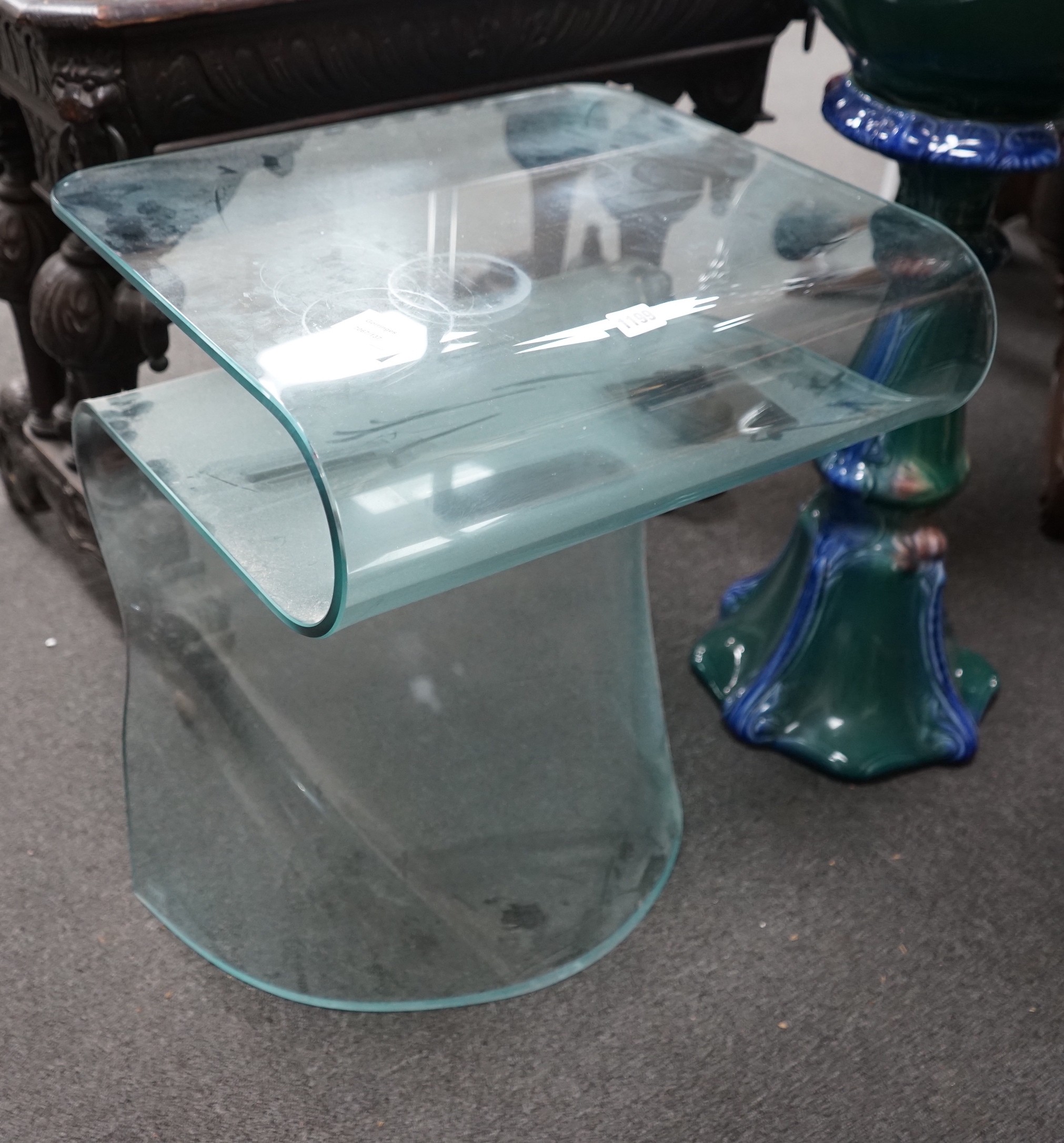 A contemporary curved glass occasional table, width 50cm, depth 43cm, height 62cm